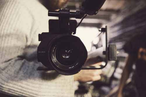 A photographer holds a camera in a studio